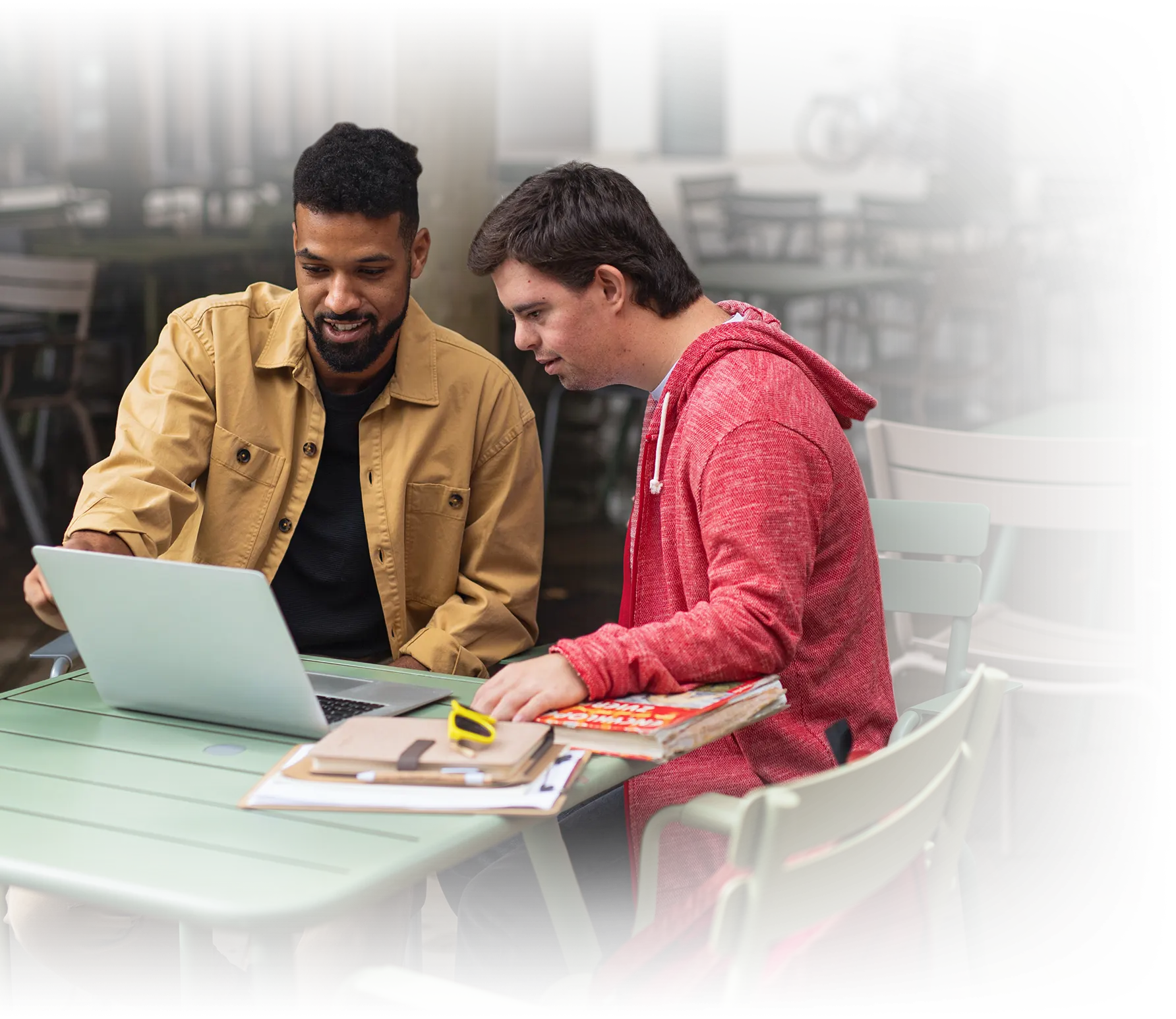 Photo of two young men looking at a laptop computer together.